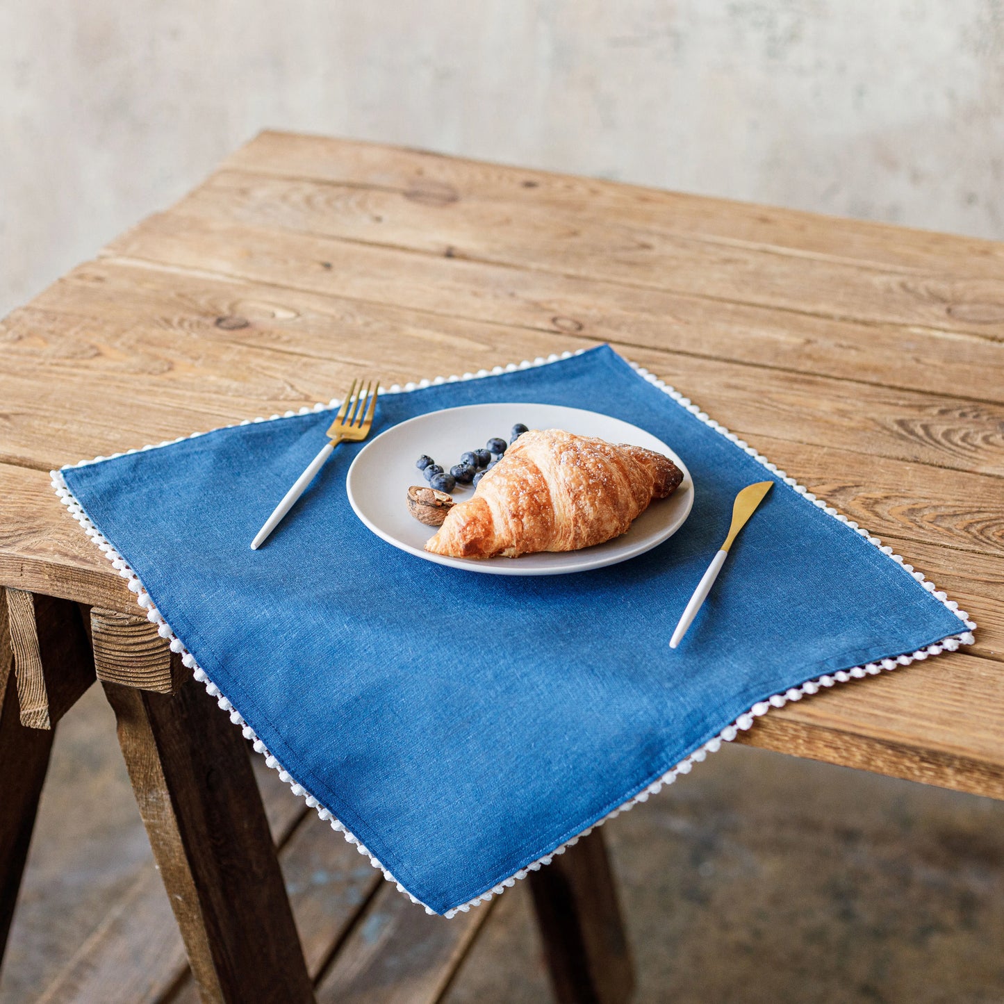 Pom pom trim linen napkin in blue color